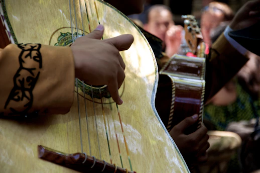 Close-up of vibrant hands playing traditional Colombian percussion instruments during a live tamborimba performance.