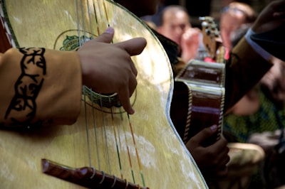 A close-up of musicians playing acoustic instruments under colorful lights.