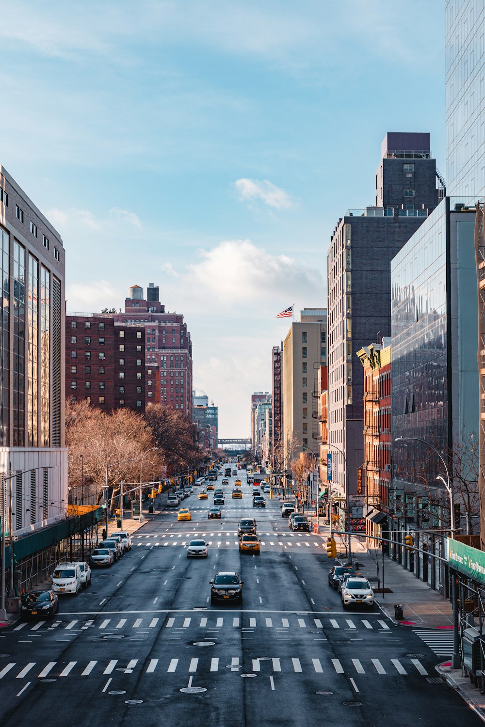 cars parked on road near high rise buildings during daytime