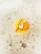 A rubber duck wearing red goggles is partially submerged in soapy water, surrounded by thick layers of foam and bubbles.