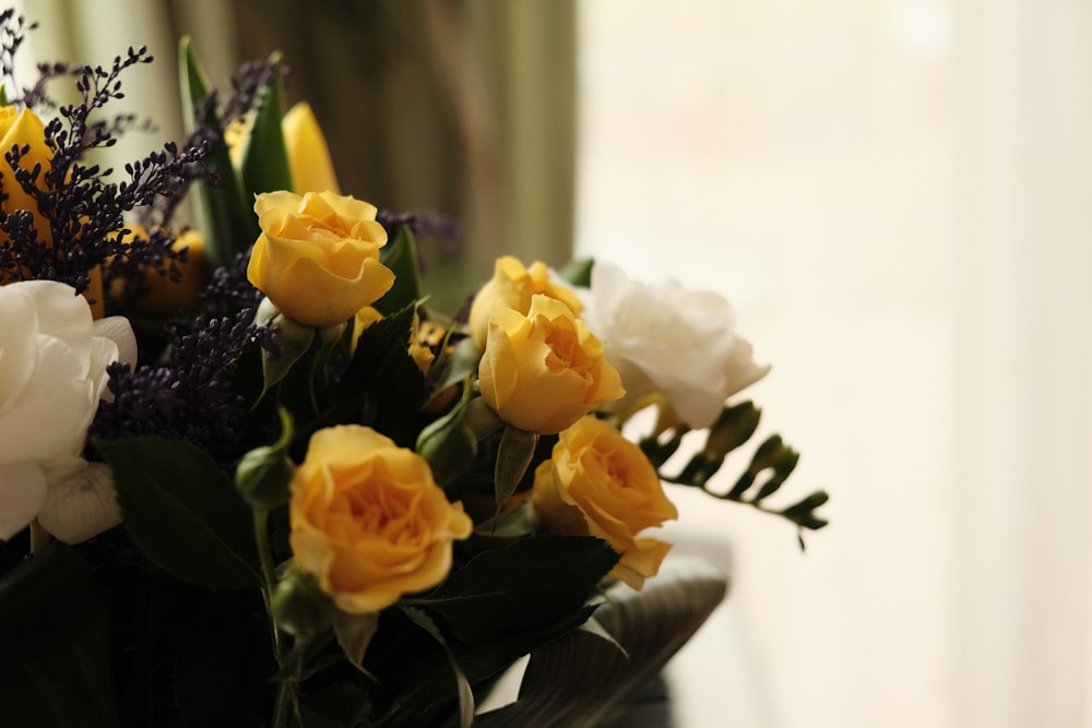 yellow roses in clear glass vase