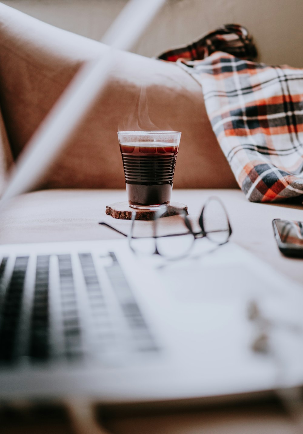 person in white red and black plaid shirt using macbook pro