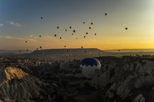 hot air balloons flying over the city during sunset in Kappadokía Turkey