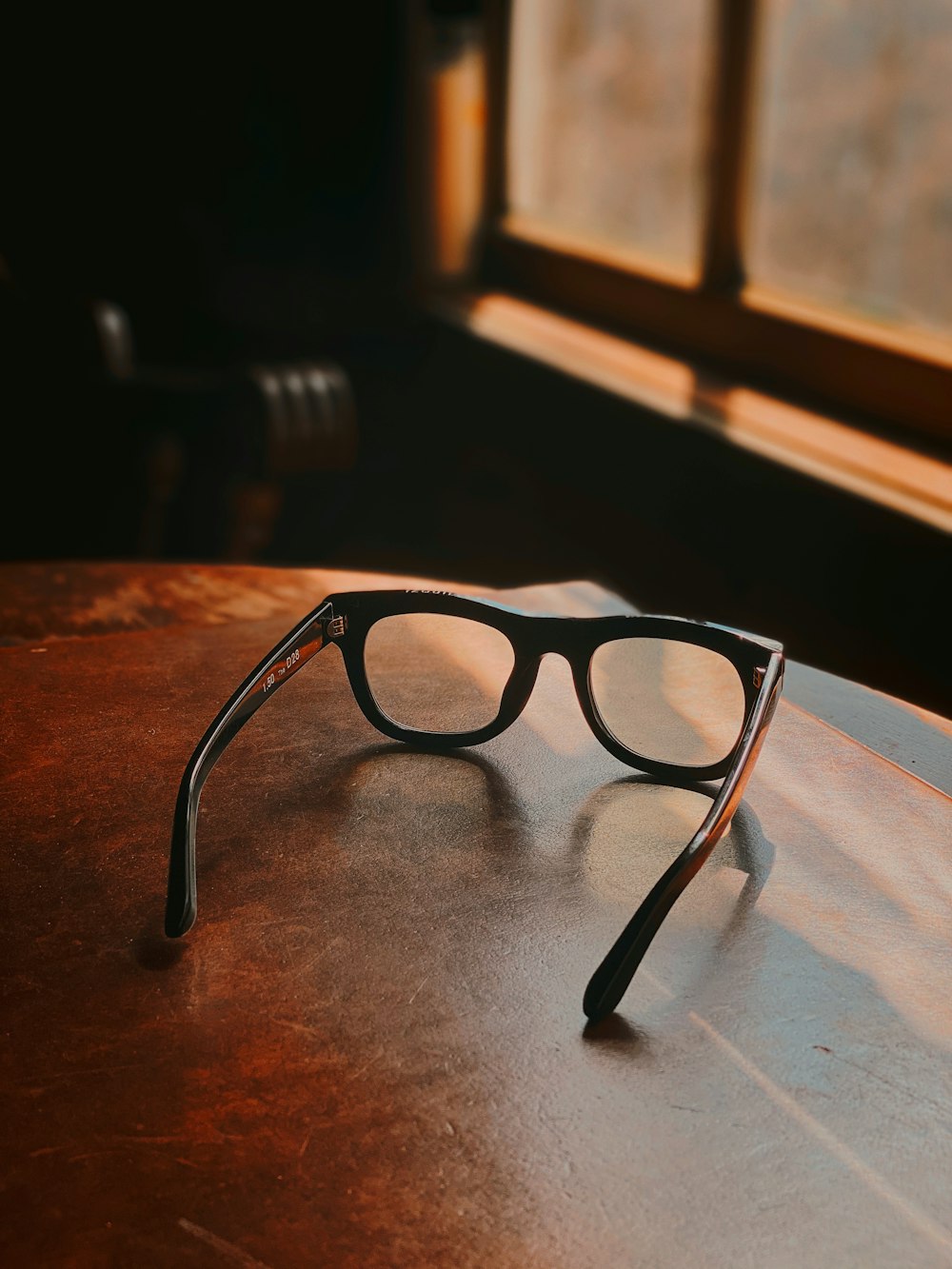 black framed eyeglasses on brown wooden table