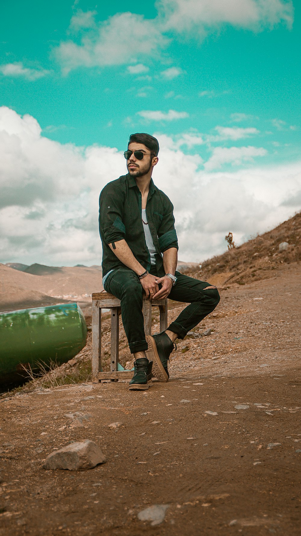 man in black jacket sitting on brown wooden bench