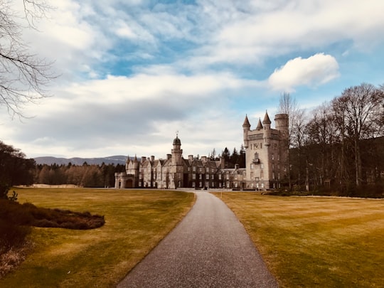 white and gray concrete building under white clouds during daytime in Balmoral Castle United Kingdom