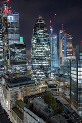 A sleek nighttime cityscape highlighting a golden-lit skyscraper under construction, symbolizing growth and luxury.