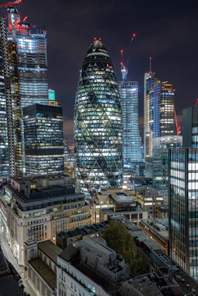 A sleek nighttime cityscape highlighting a golden-lit skyscraper under construction, symbolizing growth and luxury.