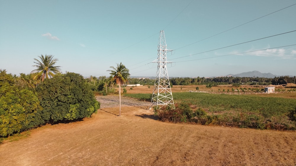 white electric tower on brown field during daytime