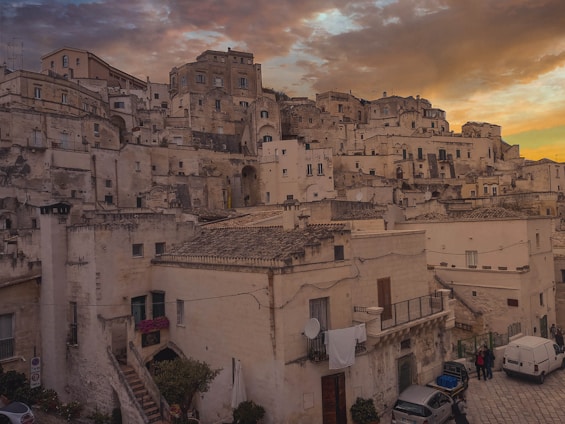 A dramatic Sicilian landscape at dusk with traditional stone buildings and red accents reflecting the festival's cinematic style.