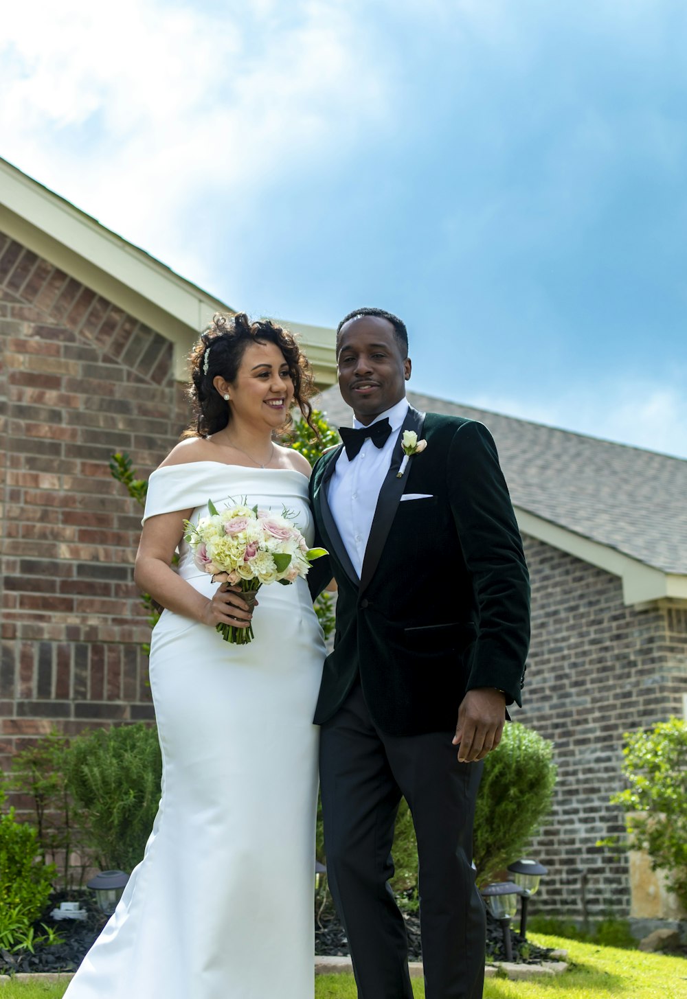 man in black suit jacket beside woman in white wedding dress