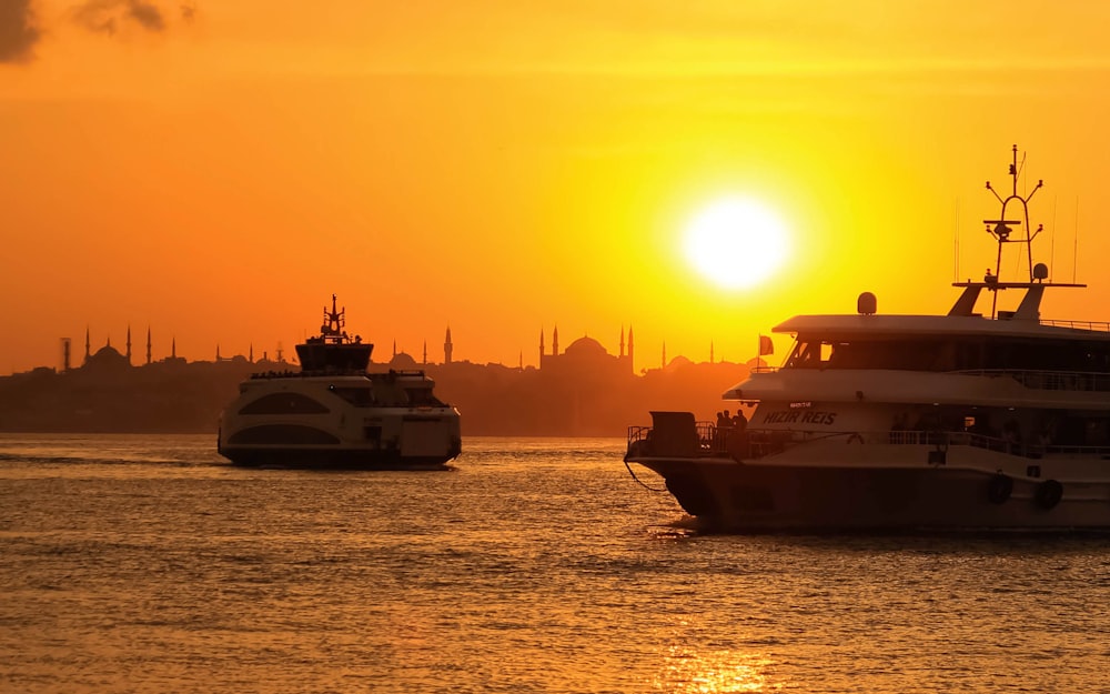 barco branco e preto no mar durante o pôr do sol