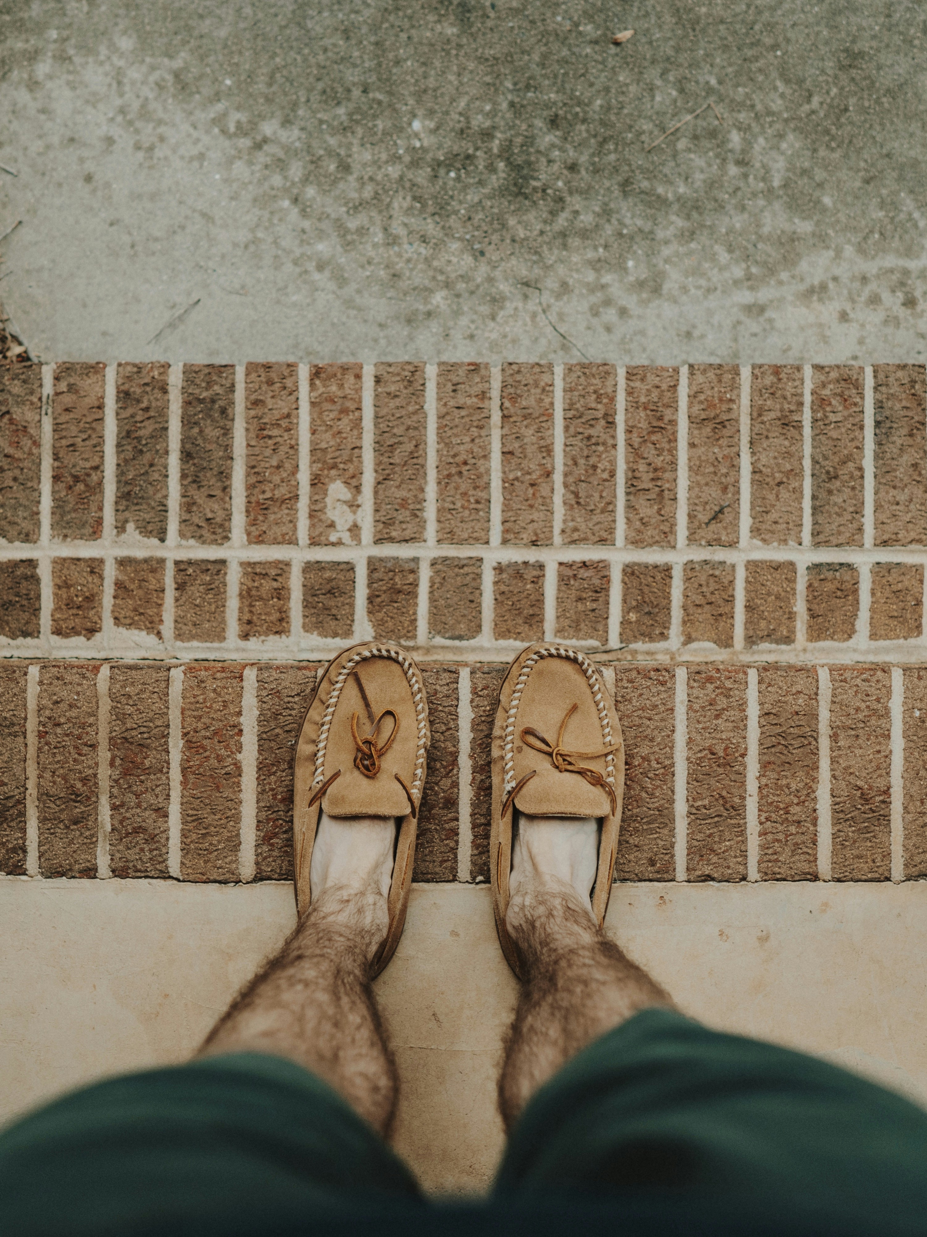 Person mit braunen Lederbootsschuhen