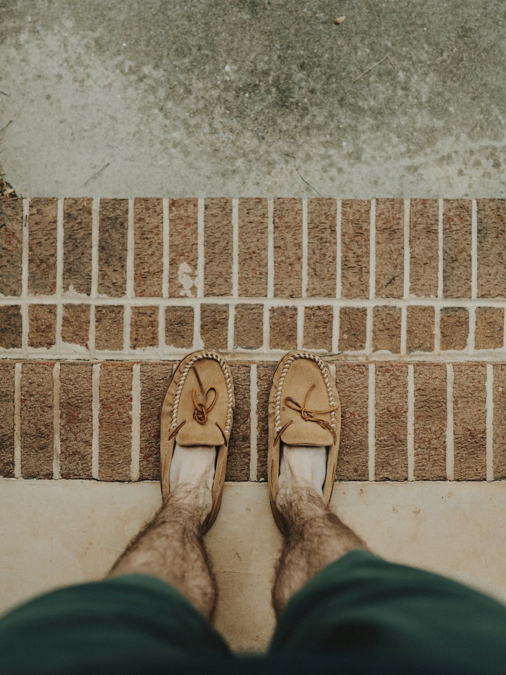 person wearing brown leather boat shoes