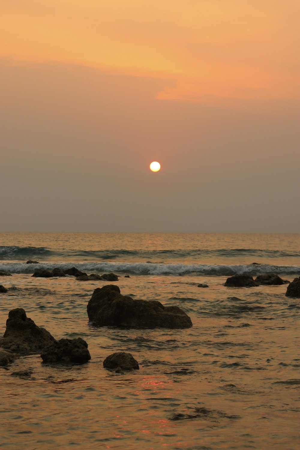 ocean waves crashing on rocks during sunset