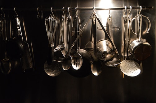 Various kitchen utensils including spatulas, ladles, and whisks displayed in a ceramic holder.