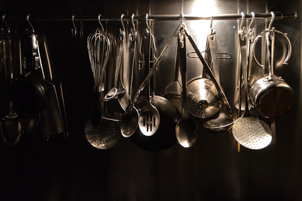 A collection of colorful kitchen utensils hanging neatly on a wall rack.