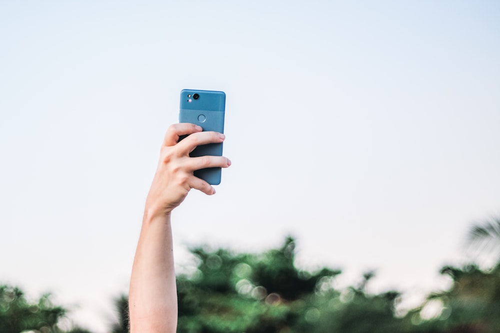 person holding blue iphone 5 c