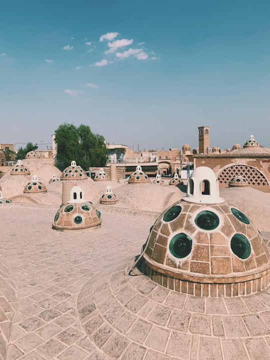 people walking on white sand during daytime in Sultan Amir Ahmad Bathhouse Iran