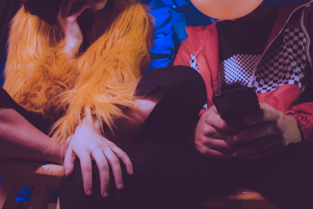 woman in black pants sitting beside woman in blue jacket