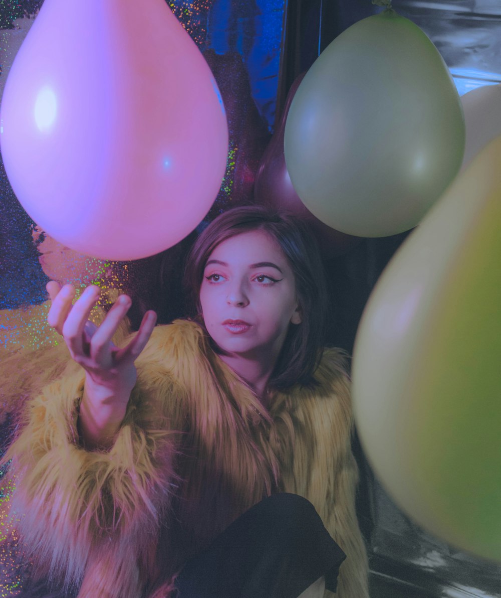 woman in black long sleeve shirt holding pink balloons