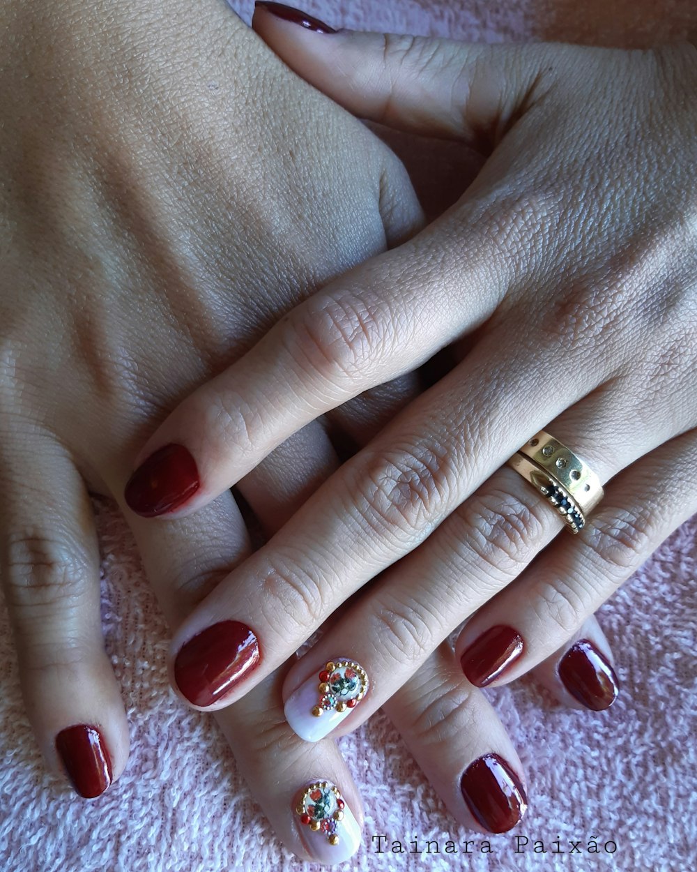 person with red and gold manicure
