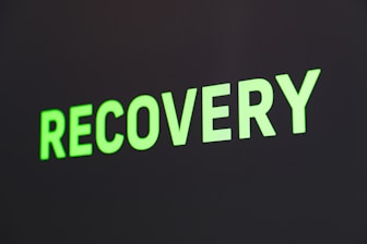 The word 'RECOVERY' is written in bright green capital letters against a dark background.
