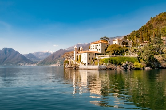 white concrete building near body of water during daytime in Villa del Balbianello Italy