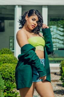 A model wearing a casual outfit made from organic cotton, standing outdoors surrounded by greenery.