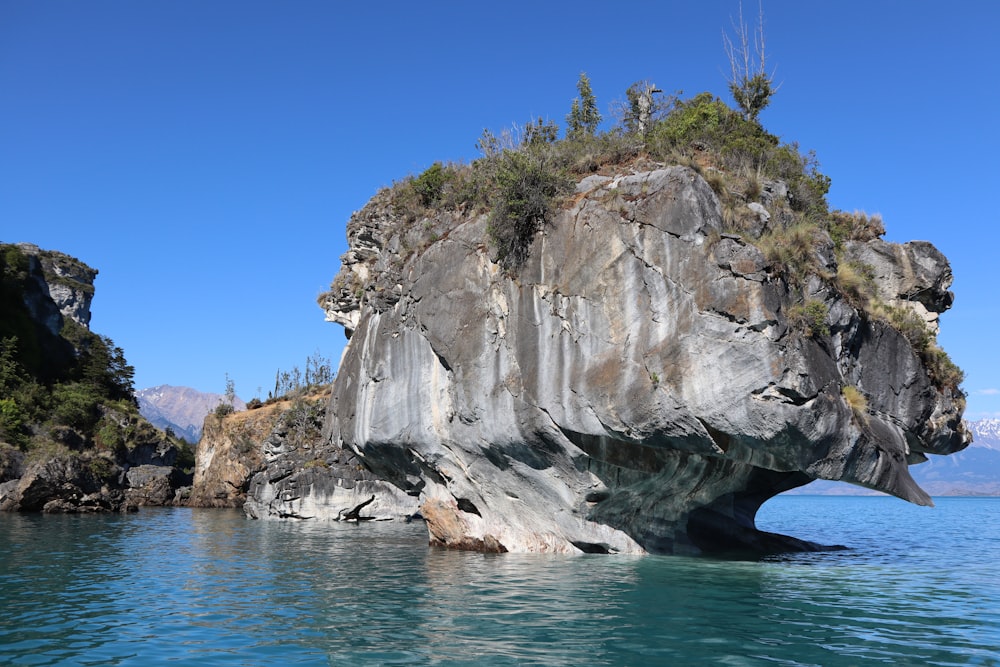 gray rock formation on blue sea under blue sky during daytime