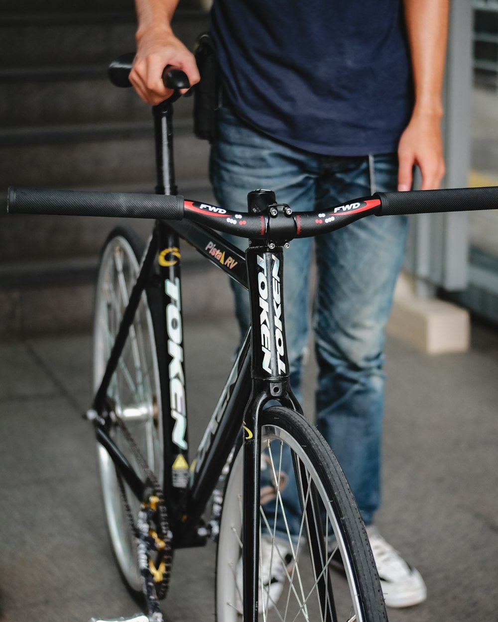 man in blue t-shirt and black pants riding black bicycle