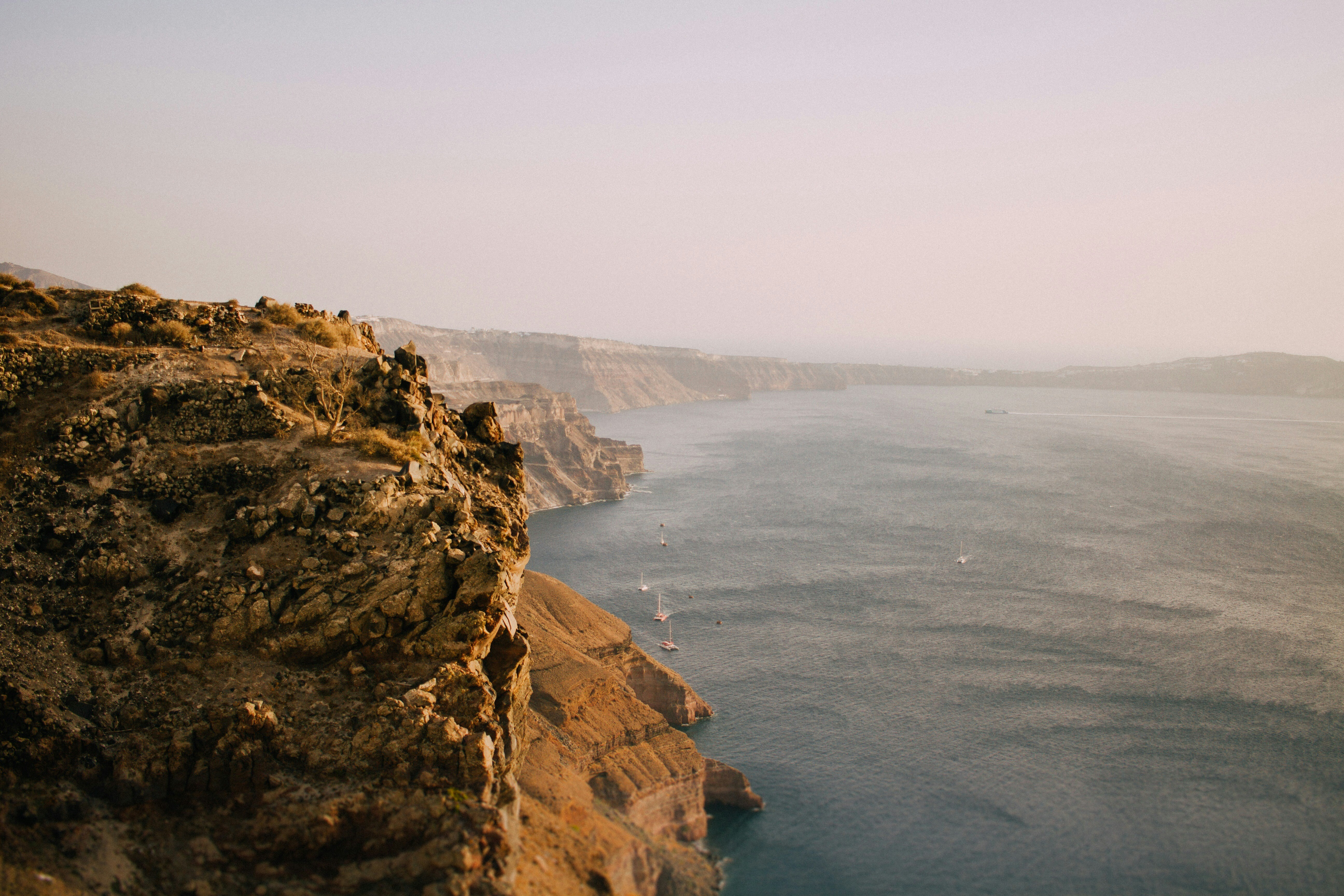 a body of water sitting next to a rocky cliff