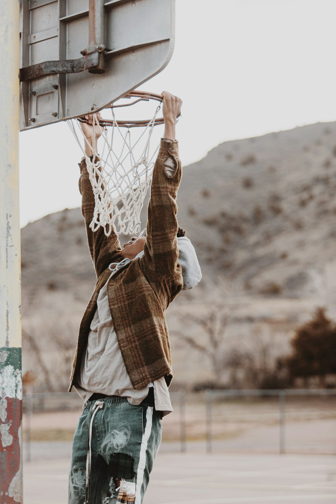 person in brown jacket playing basketball during daytime