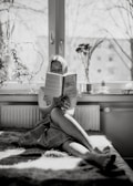 A patient reading a medical book in a bright room.