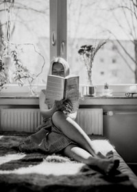 Person reading a mental health book in a calm, sunlit room.