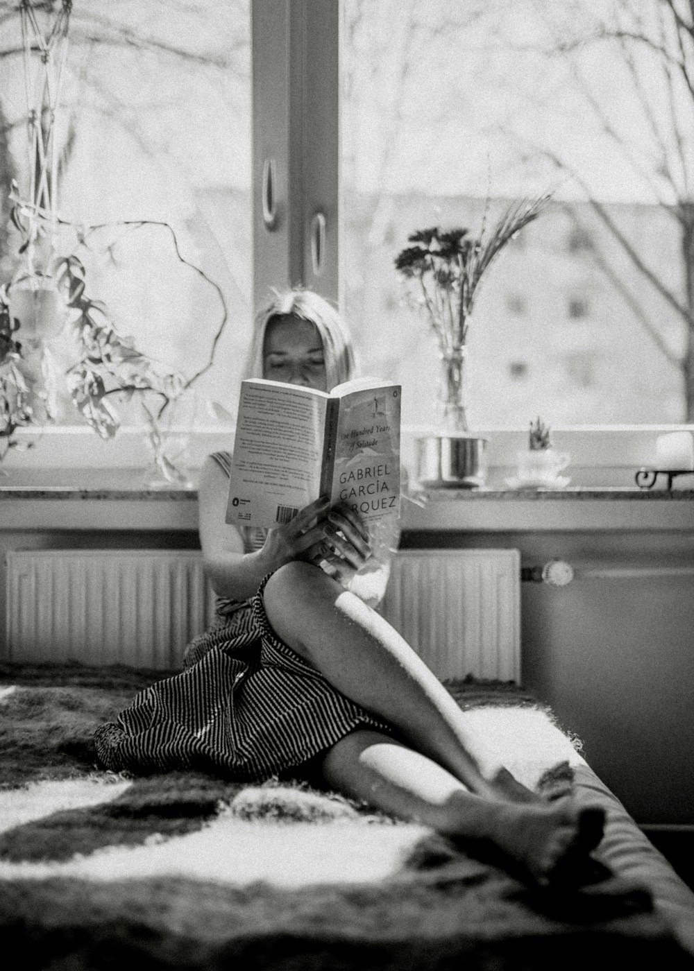 woman reading book on bed