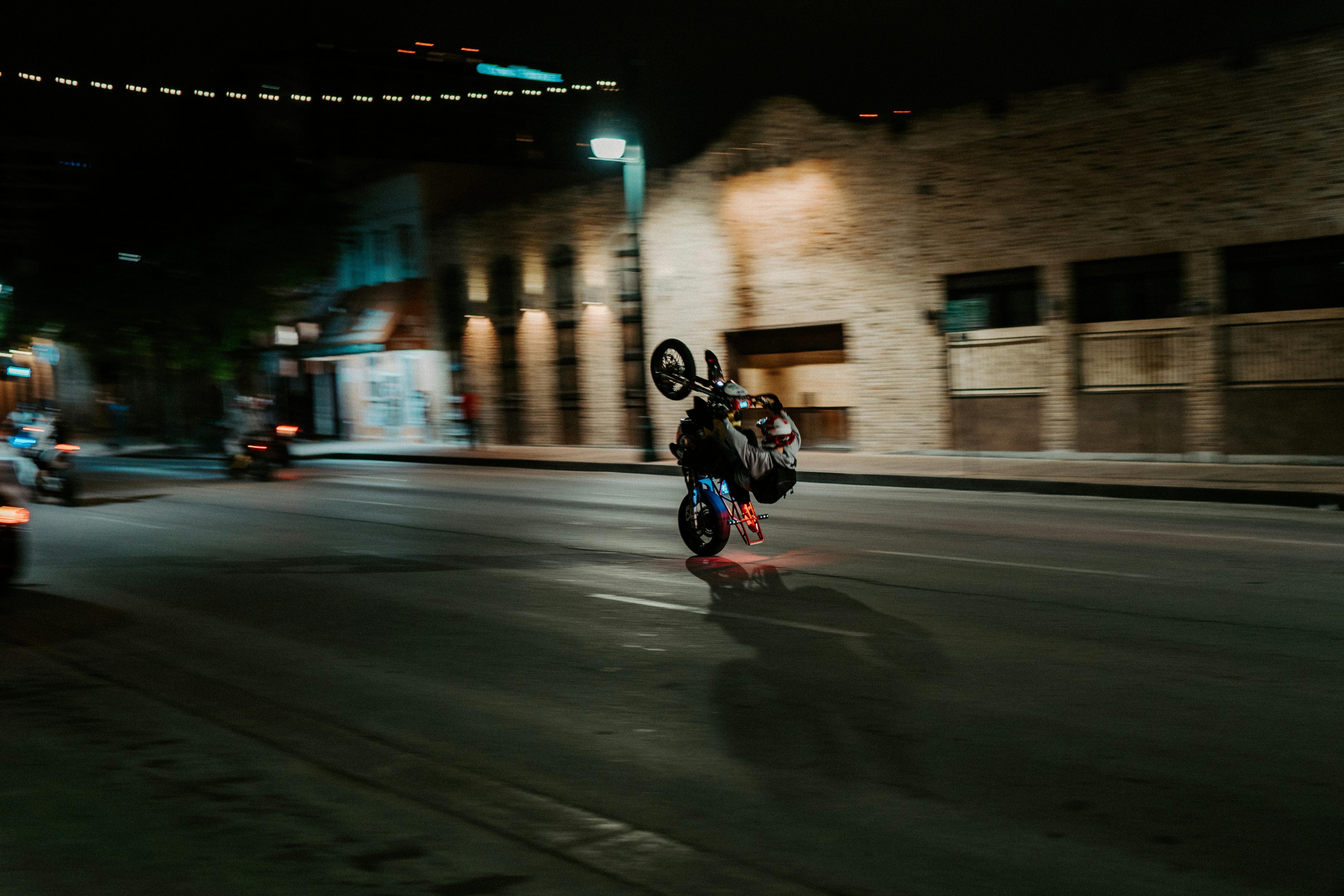 man in black jacket riding motorcycle on road during night time