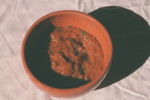 brown ceramic bowl on white textile