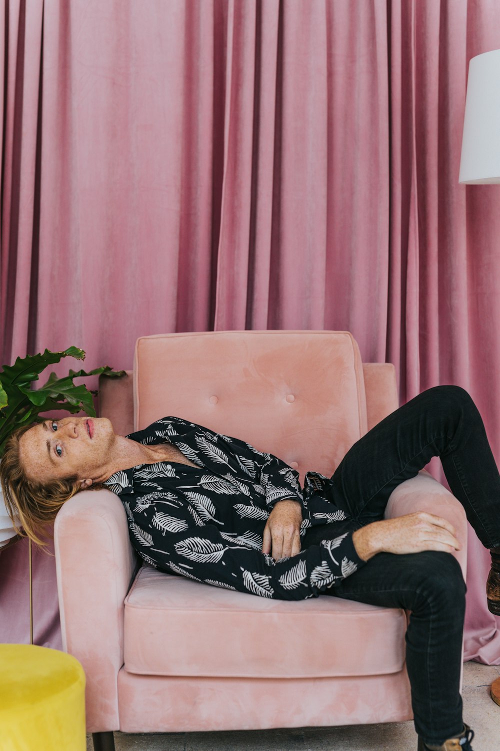 woman in black and white floral dress lying on sofa