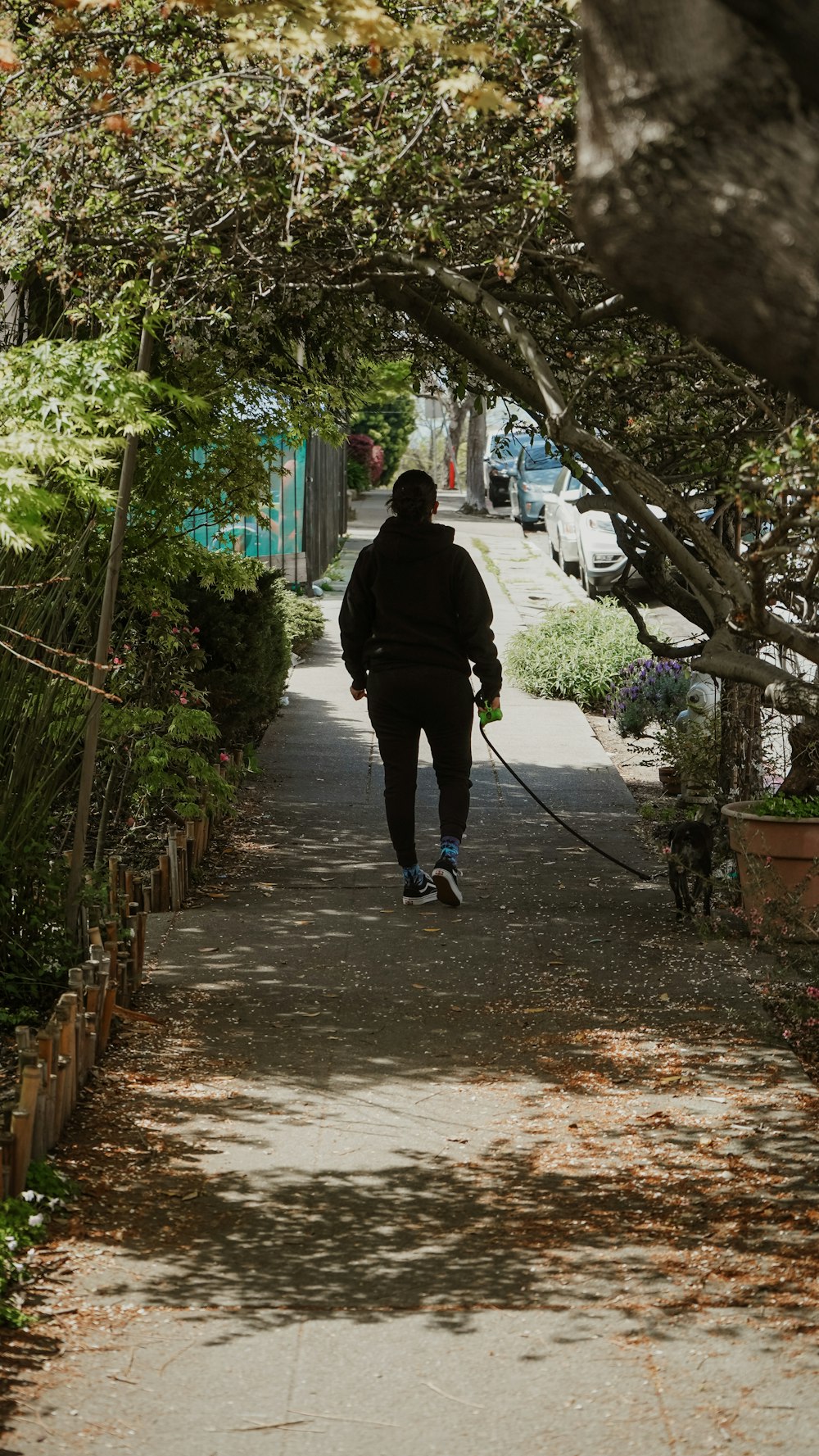 man in black jacket walking on pathway during daytime