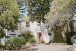 white concrete house near green trees during daytime