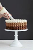 person holding white ice cream cone with brown and white round cake
