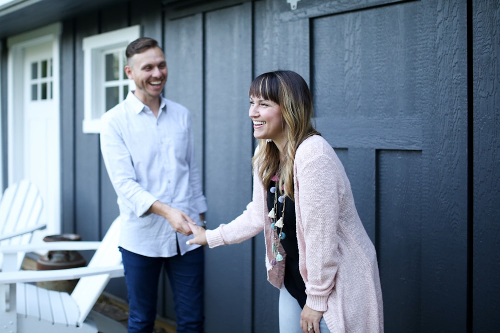 man in white dress shirt standing beside woman in gray cardigan