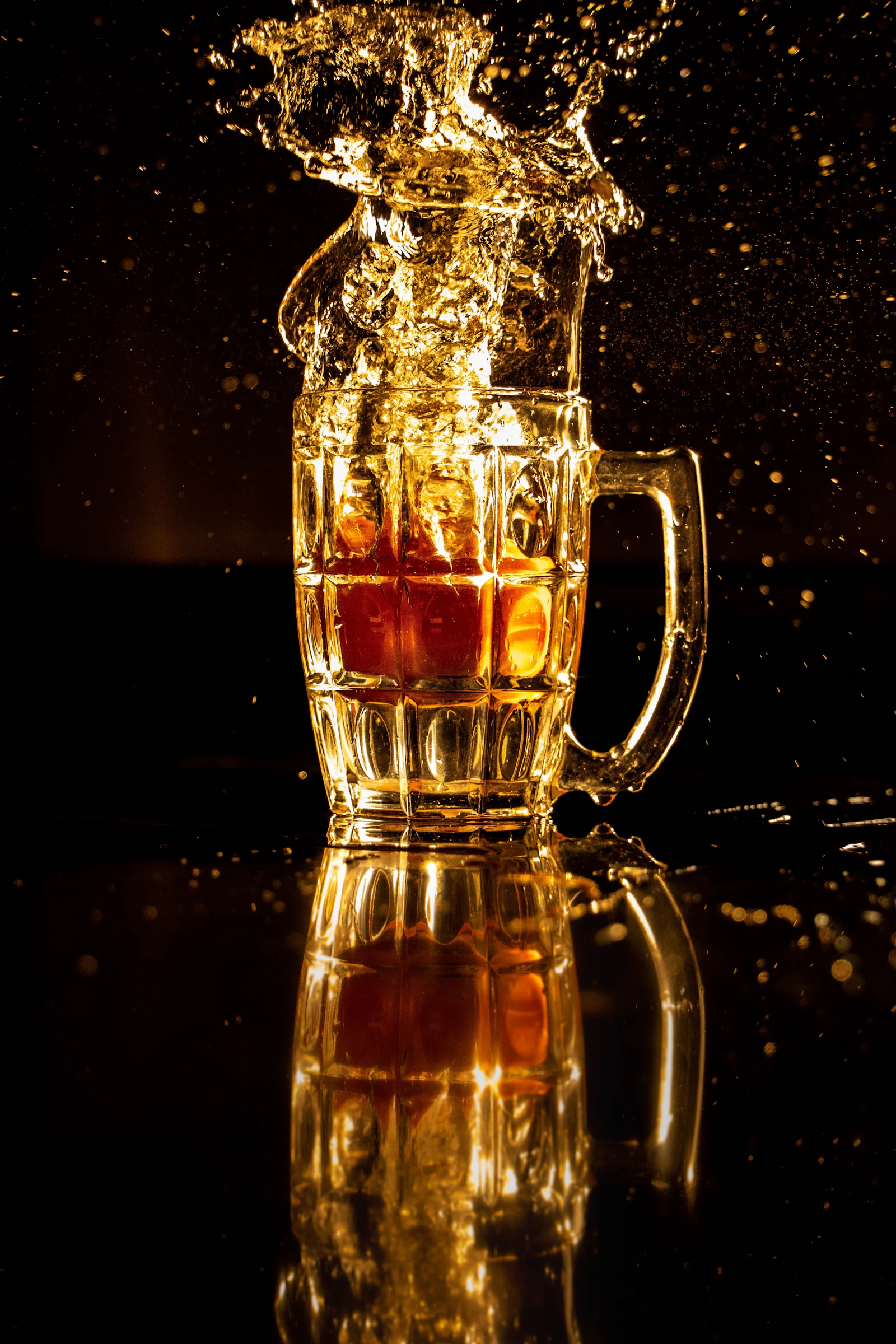 A mug of beer caught mid-splash against black