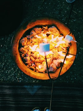 A cozy campfire setup with marshmallows roasting on sticks.