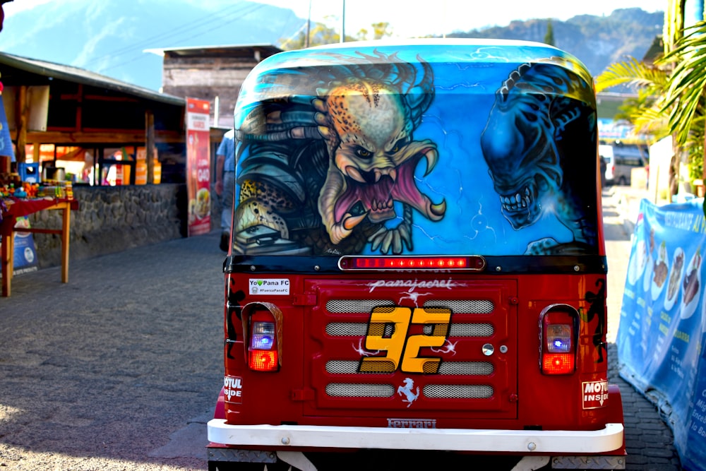 red and blue bus with graffiti