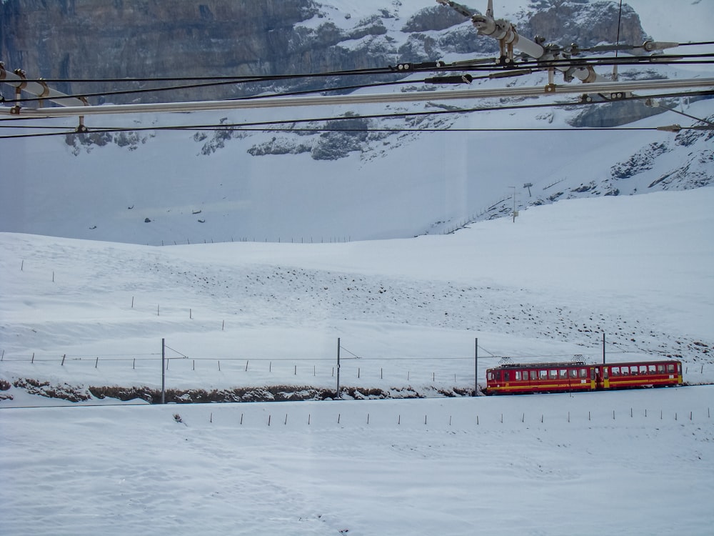 red and white train on snow covered ground during daytime