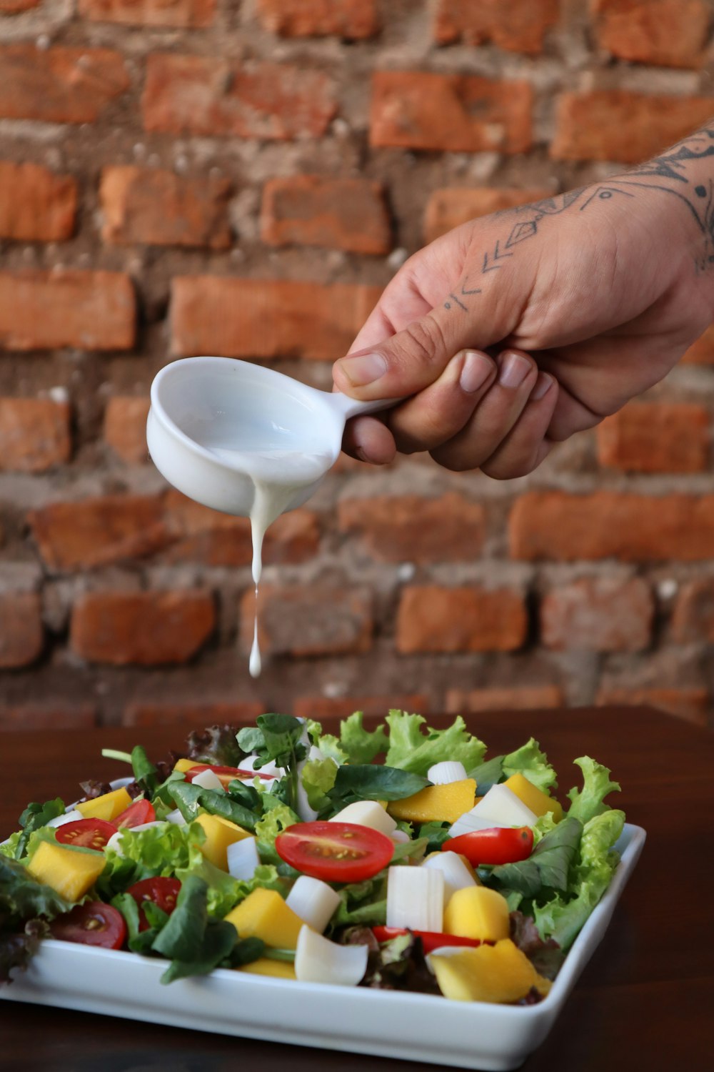 person holding stainless steel spoon with sliced vegetables