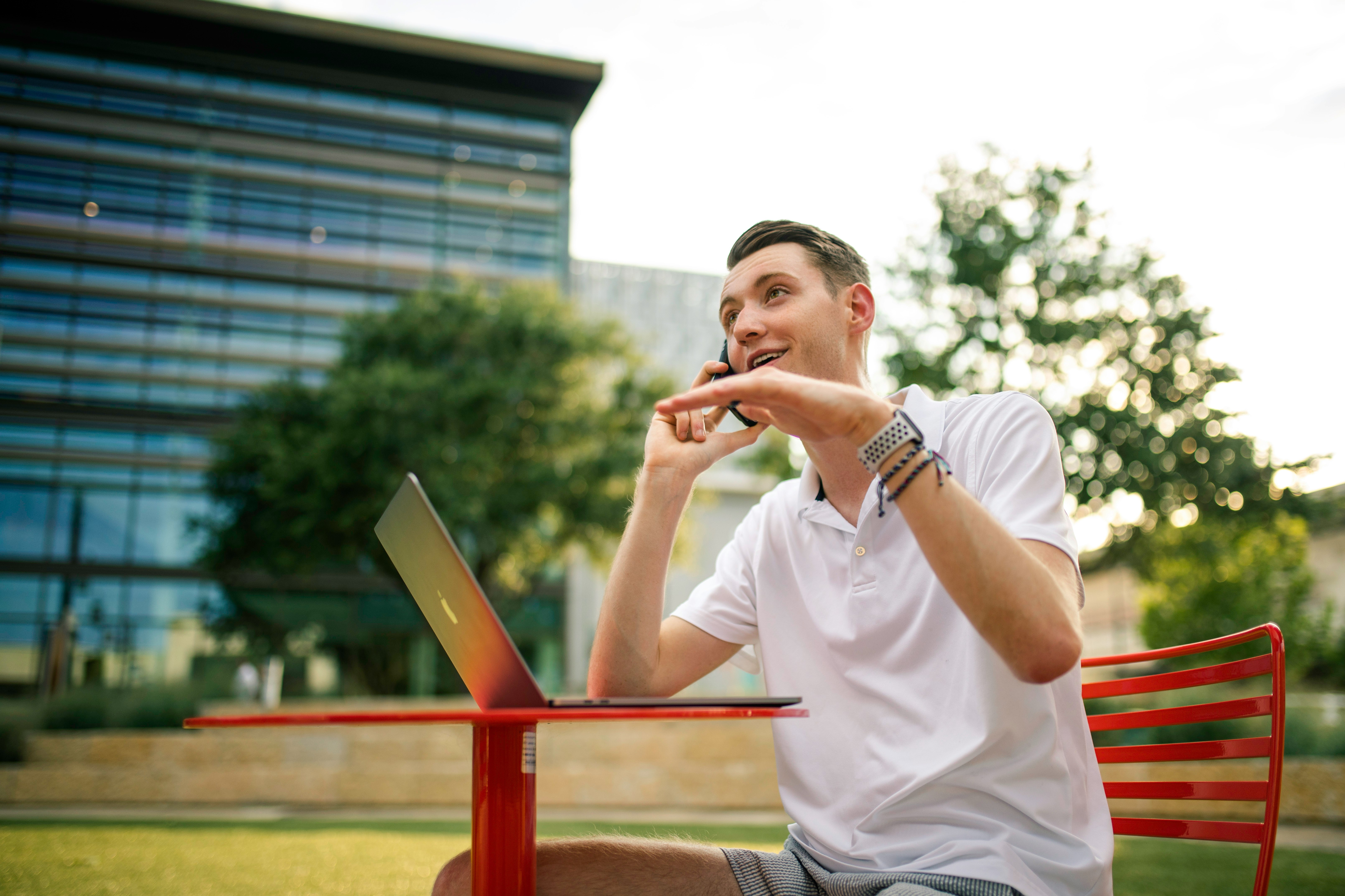 man in white crew neck t-shirt holding gray laptop computer