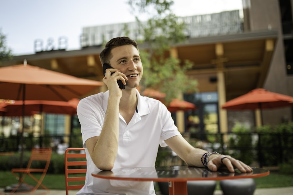 man in white crew neck t-shirt sitting on red bench